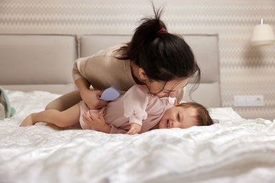 Mother and daughter on bed at home