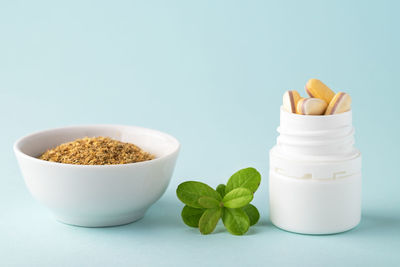 Vitamins and herbal supplements in jars with a green plant . dietary supplements.