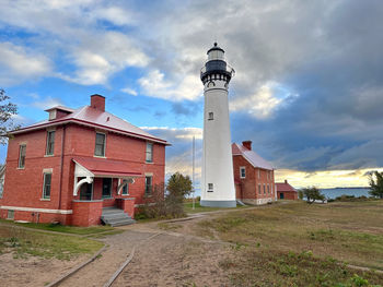 Lighthouse by sea against sky