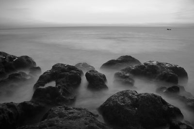 Rocks in sea against sky
