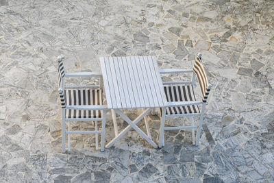 High angle view of a white outdoor table with a couple of chairs in a terrace 