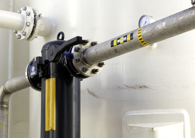 Low angle view of pipe connected to container in factory