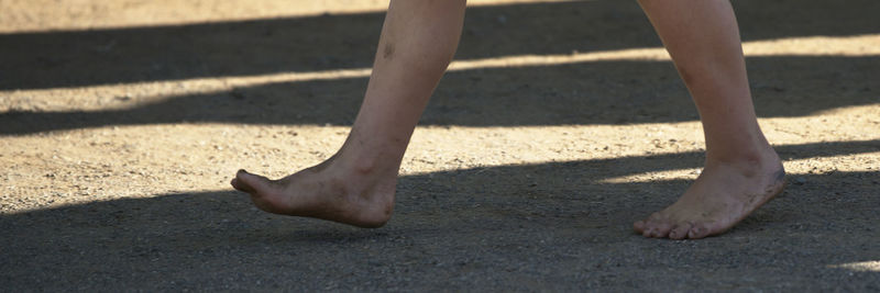 Low section of person shadow on sand