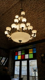 Low angle view of illuminated chandelier hanging on wall