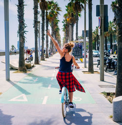 Woman riding bicycle on road in city