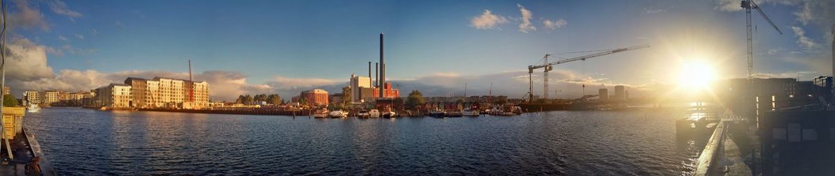 Panoramic view of sea and buildings against sky during sunset