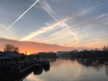 Scenic view of vapor trails in sky at sunset