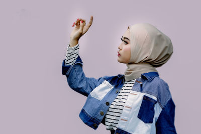 Rear view of boy holding hands against white background