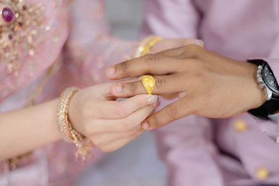 Midsection of couple holding hands