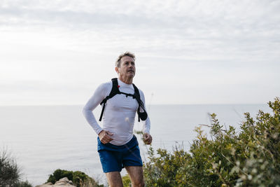 Full length of man standing in sea against sky