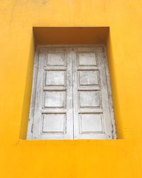 Low angle view of closed door of yellow building
