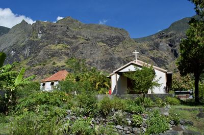 Houses and trees on mountain against sky