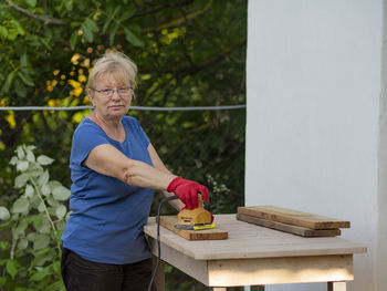 Man holding food while standing by plants in yard