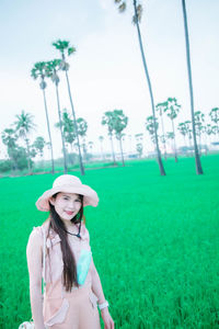 Portrait of beautiful woman standing on field