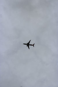 Low angle view of silhouette airplane flying in sky