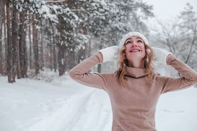 Christmas, holidays and season concept. young happy woman blowing snow in the winter forest nature.