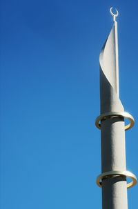 Low angle view of pole against building against clear blue sky