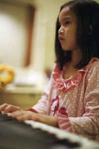 Portrait of woman looking away while sitting at home