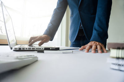 Midsection of man working on table