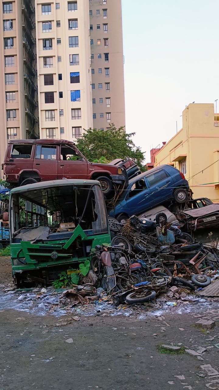 architecture, building exterior, built structure, city, building, urban area, transportation, mode of transportation, day, garbage, no people, motor vehicle, damaged, transport, nature, environmental issues, street, demolition, vehicle, car, outdoors, residential area, apartment