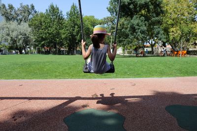 Rear view of girl on swing at the playground