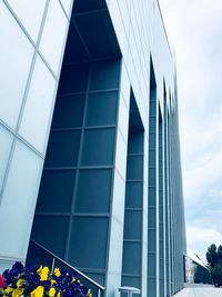 Low angle view of modern glass building against sky