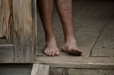 Low section of barefoot man on wooden  floor