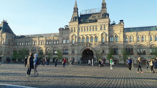 People in front of building against clear sky