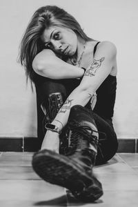 Portrait of young woman sitting on hardwood floor