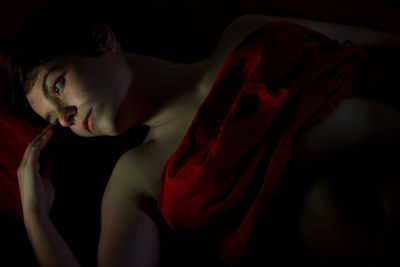 Close-up of young woman over black background