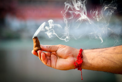 Cropped hand of man holding incense