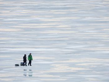 People on shore against sky