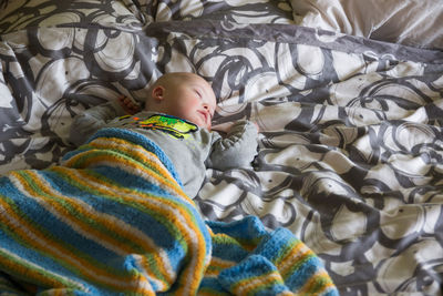 High angle view of baby with down syndrome sleeping on bed