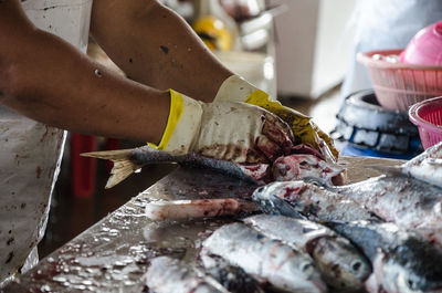 Man feeding fish for sale at market