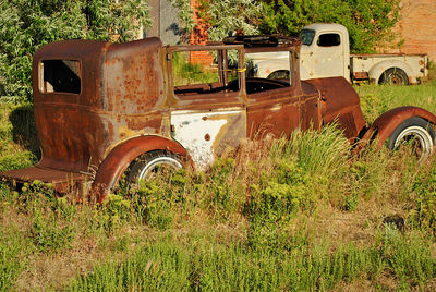 Old abandoned car on field