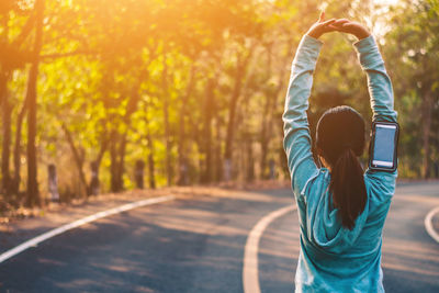 Rear view of woman exercising on road