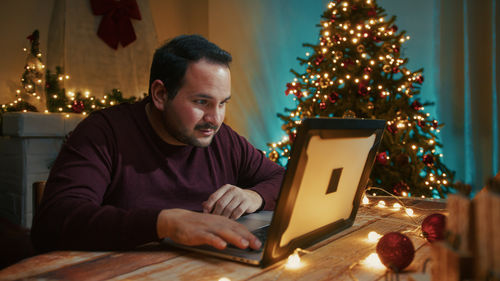 Portrait of young man using digital tablet at home