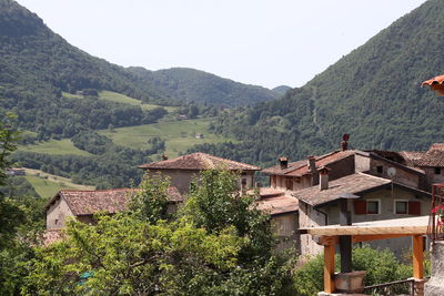 Scenic view of village by mountains against clear sky