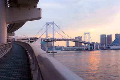 View of suspension bridge in city at sunset