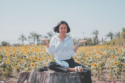 Portrait of smiling young woman sitting on land