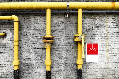 Yellow pipes against wall