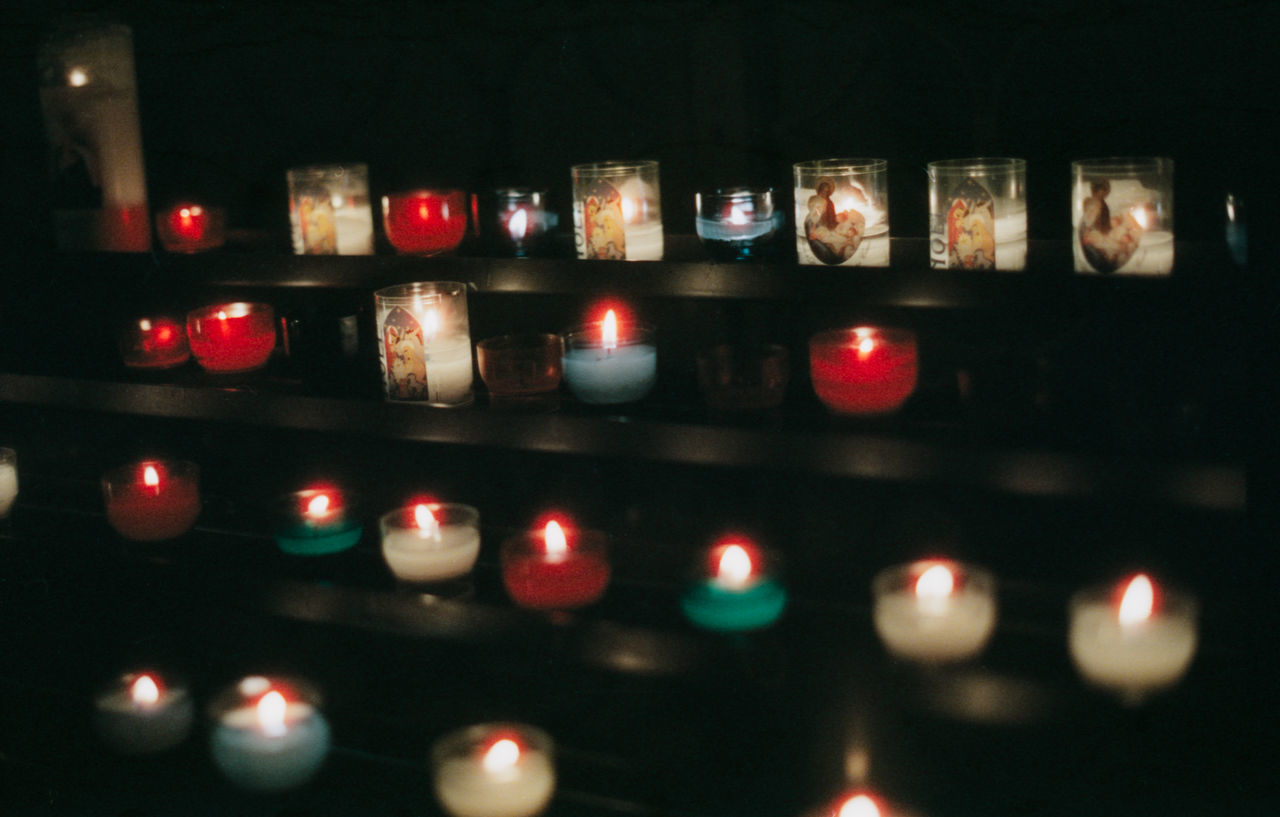 candle, indoors, illuminated, no people, burning, fire, in a row, flame, close-up, tea light, shelf, still life, selective focus, fire - natural phenomenon, lighting equipment, heat - temperature, religion, large group of objects, side by side, choice