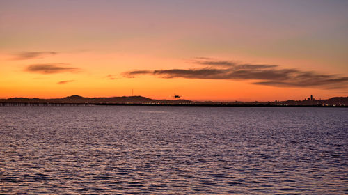 Scenic view of sea against dramatic sky during sunset