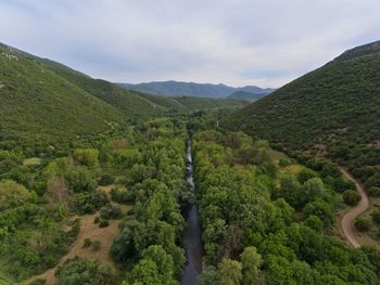 Scenic view of green landscape and mountains against sky