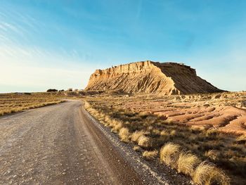 Road amidst land against sky