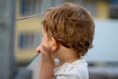 Close-up of boy standing by railing