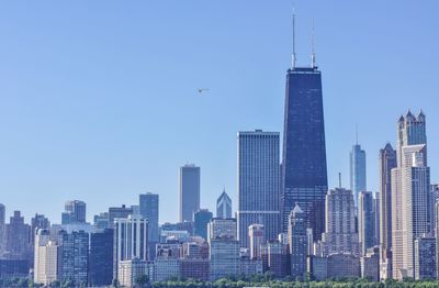 Skyscrapers in city against blue sky