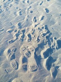 High angle view of footprints on sand at beach