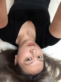 Portrait of woman lying on bed at home