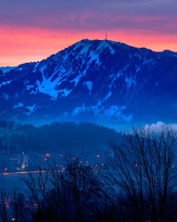 Scenic view of snowcapped mountains against sky at sunset